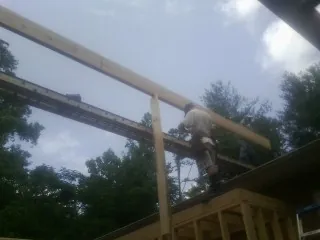 Carpenter setting a ridge beam over a new addition frame — Ice Dam Removal by Roofing Brothers in New Meadows