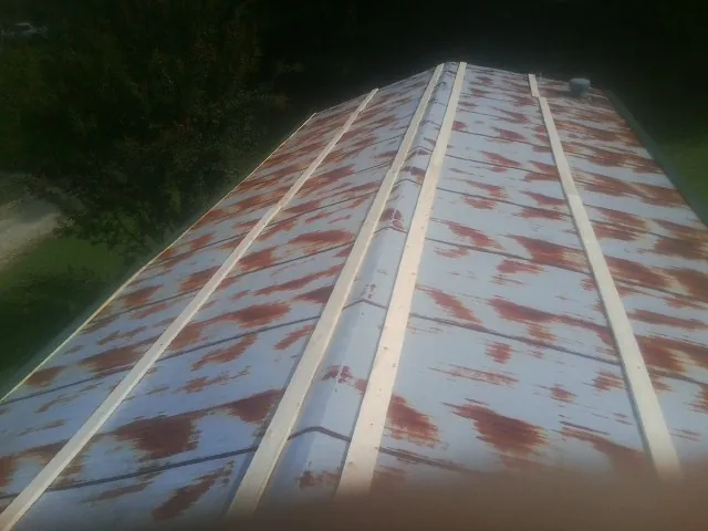 Rusted metal roof panels with new wood purlins before replacement — Storm Damage Roof Repair in New Meadows by Roofing Brothers