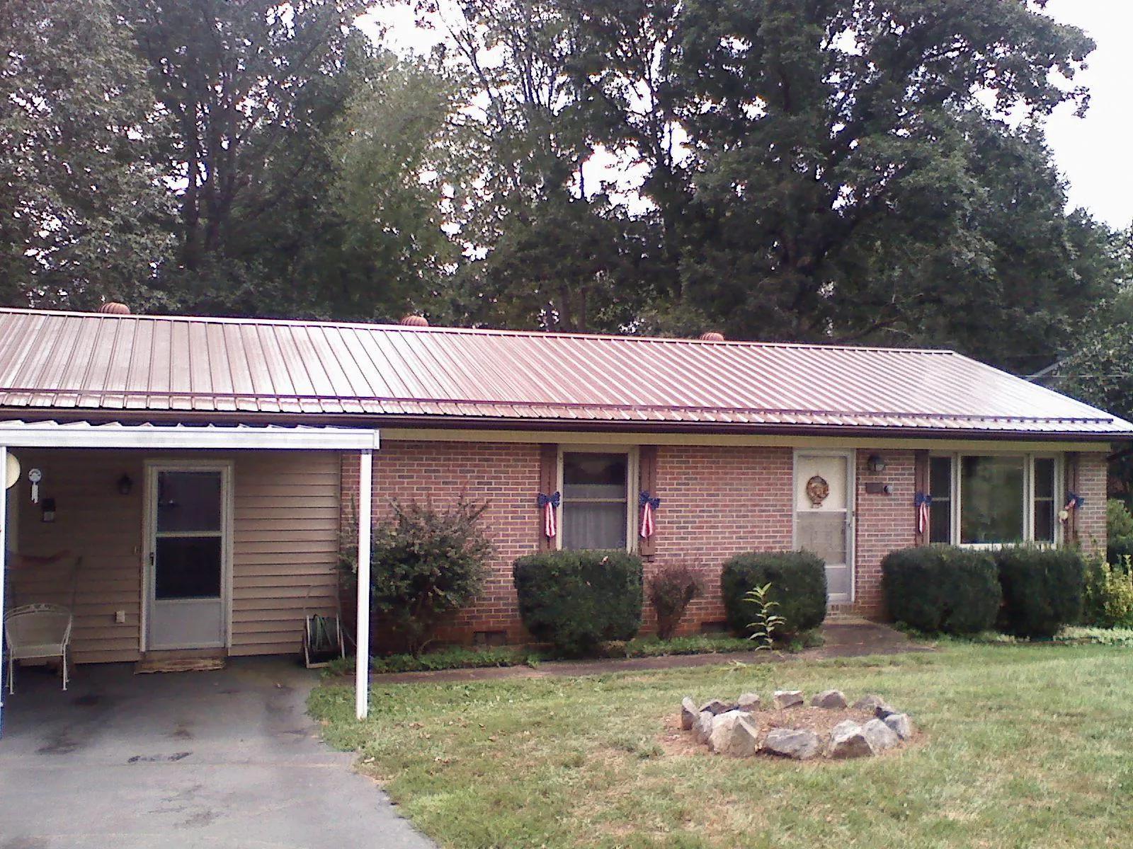 Bronze metal roof and carport on a brick ranch home — Roof Repair work by our crew in New Meadows